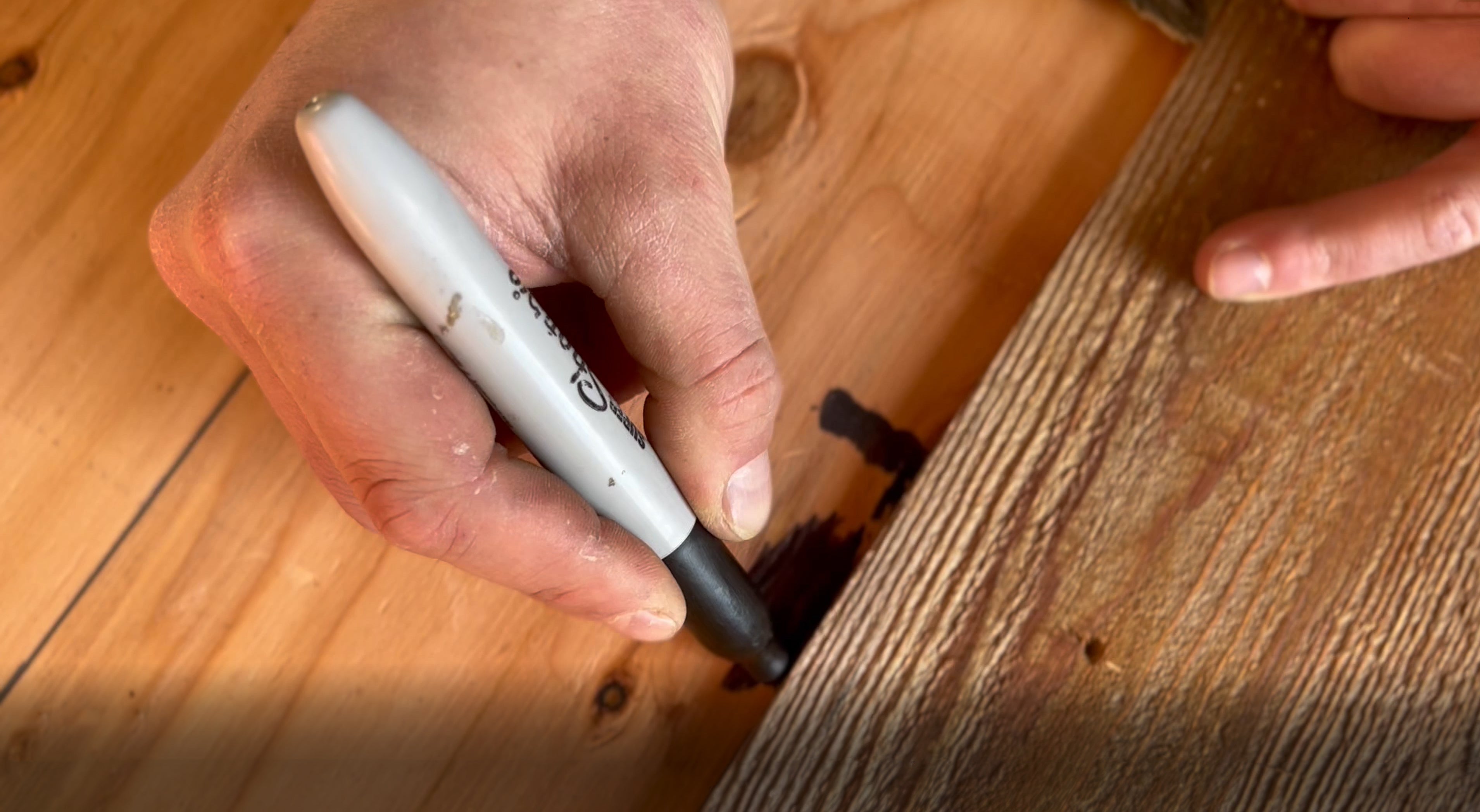 How to hide knotholes on reclaimed wood walls using a black Sharpie marker.