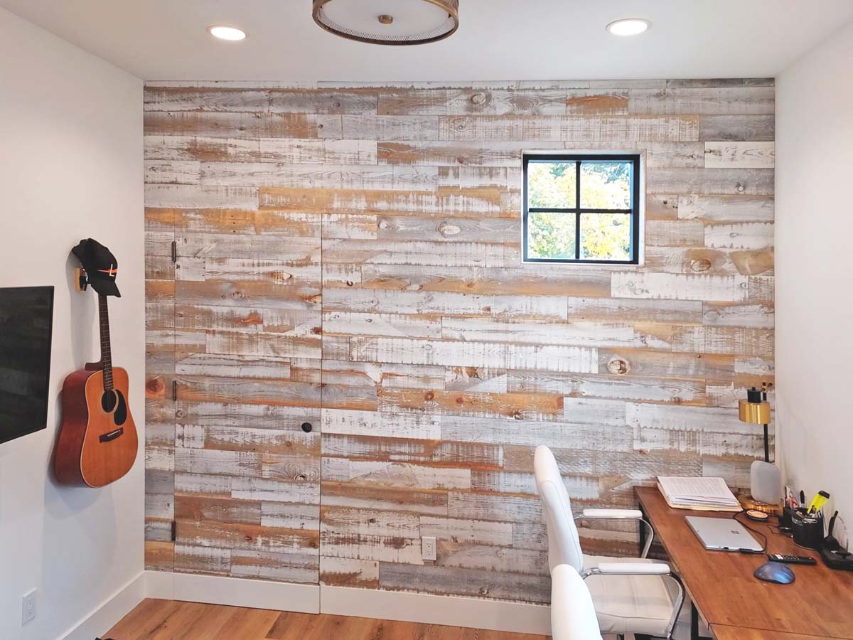 Modern rustic styled home office with a distressed whitewashed finish wood wall made from reclaimed wood by Centennial Woods