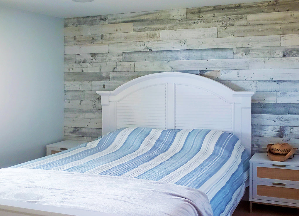 Coastal style bedroom with a white reclaimed wood wall