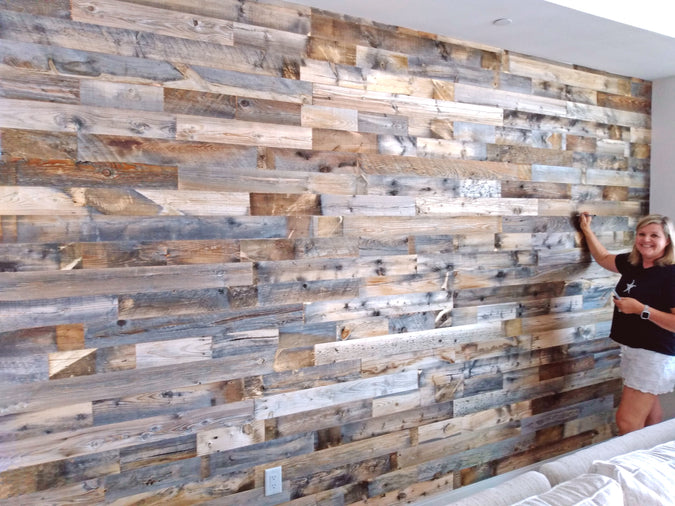DIY reclaimed wood paneling on a living room wall in shades of grey, brown, and cinnamon.