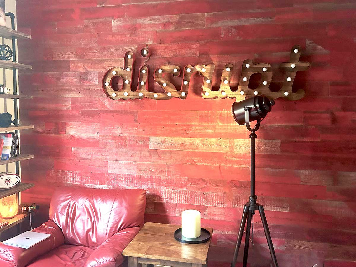 Wood accent wall using red barn wood in an industrial style.