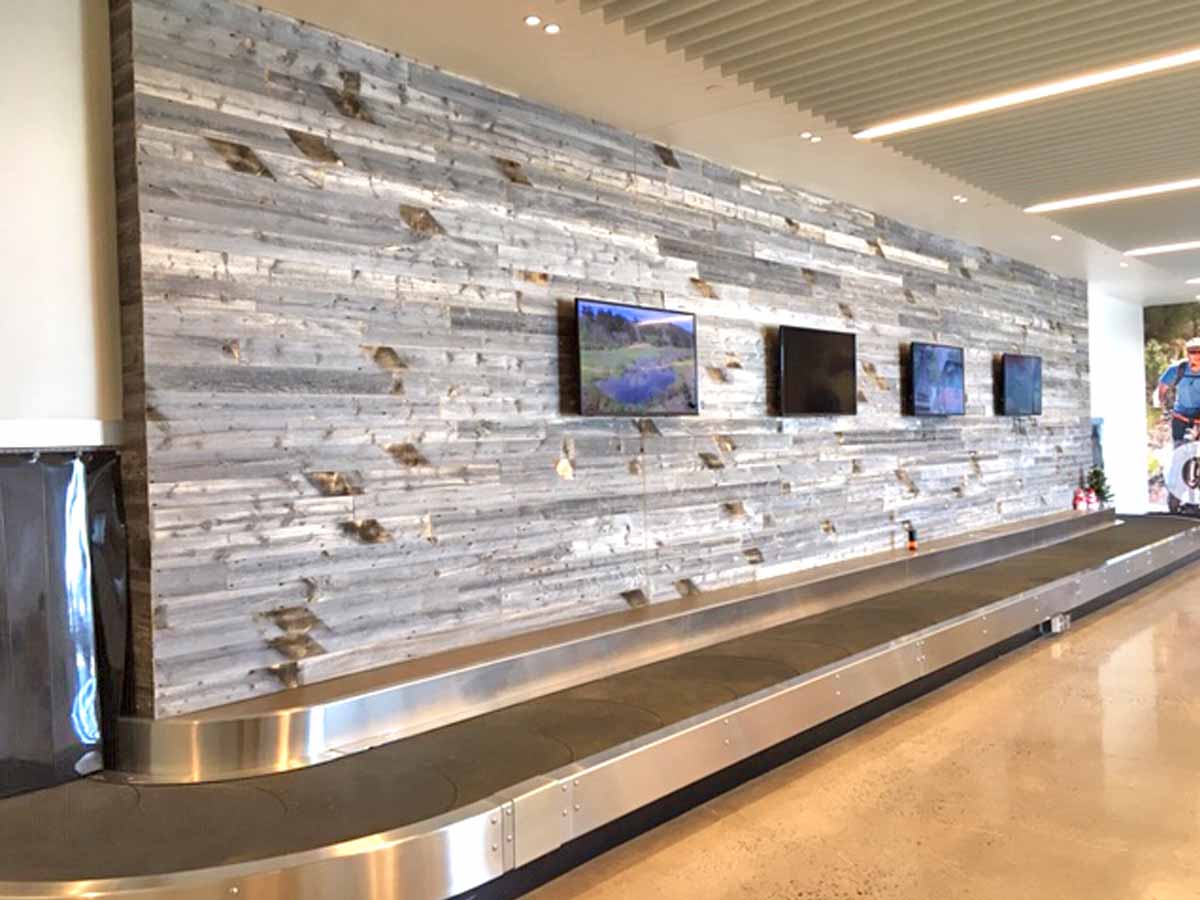 Grey reclaimed wood wall at the Cheyenne Airport baggage claim.