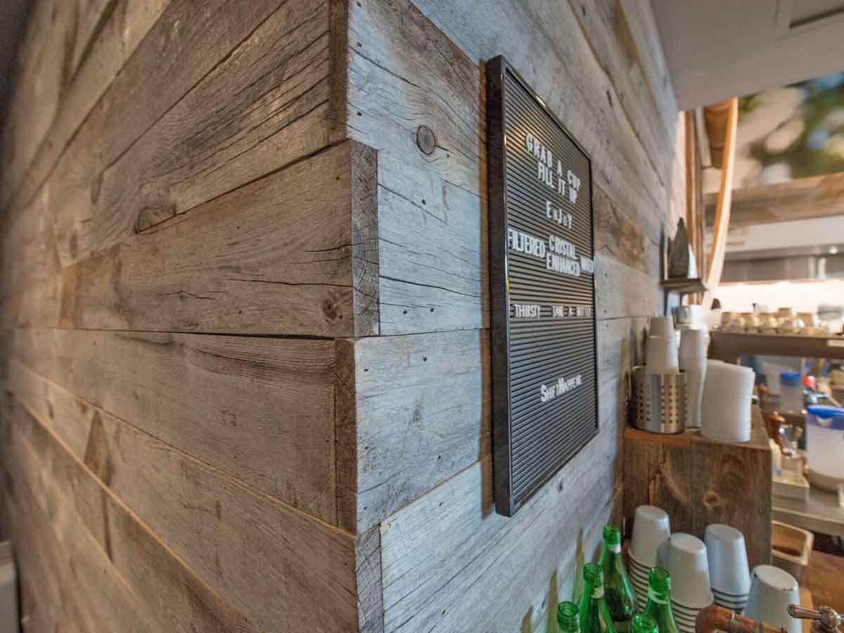 Grey reclaimed wood wall design with natural edges in a restaurant.