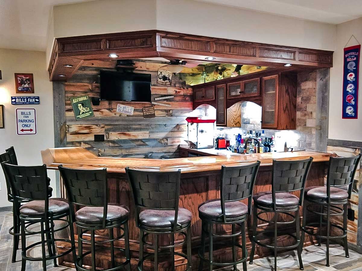 Basement bar and game room with a reclaimed wood accent wall devoted to the Buffalo Bills.