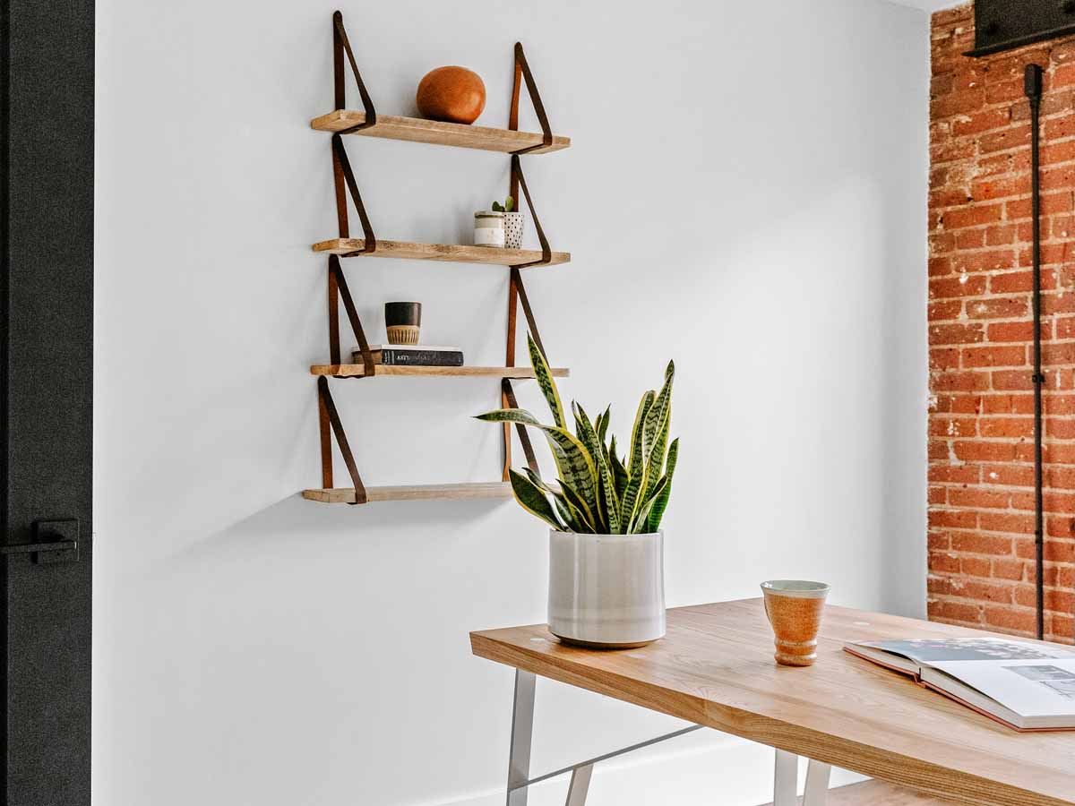 Brown reclaimed wood wall decor leather strap shelves by Centennial Woods and Range Leather.