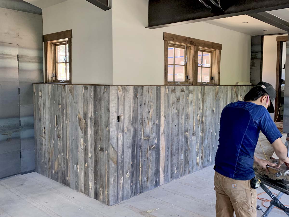 Grey, reclaimed wood wainscotting being installed in a modern Summit County Colorado condo complex.