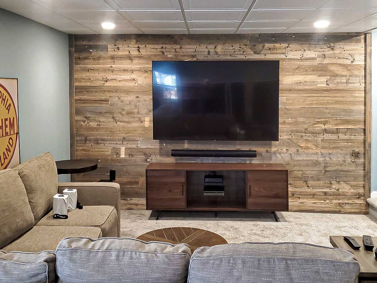 Reclaimed wood wall in a basement tv room in Centennial Woods' Cheyenne finish.
