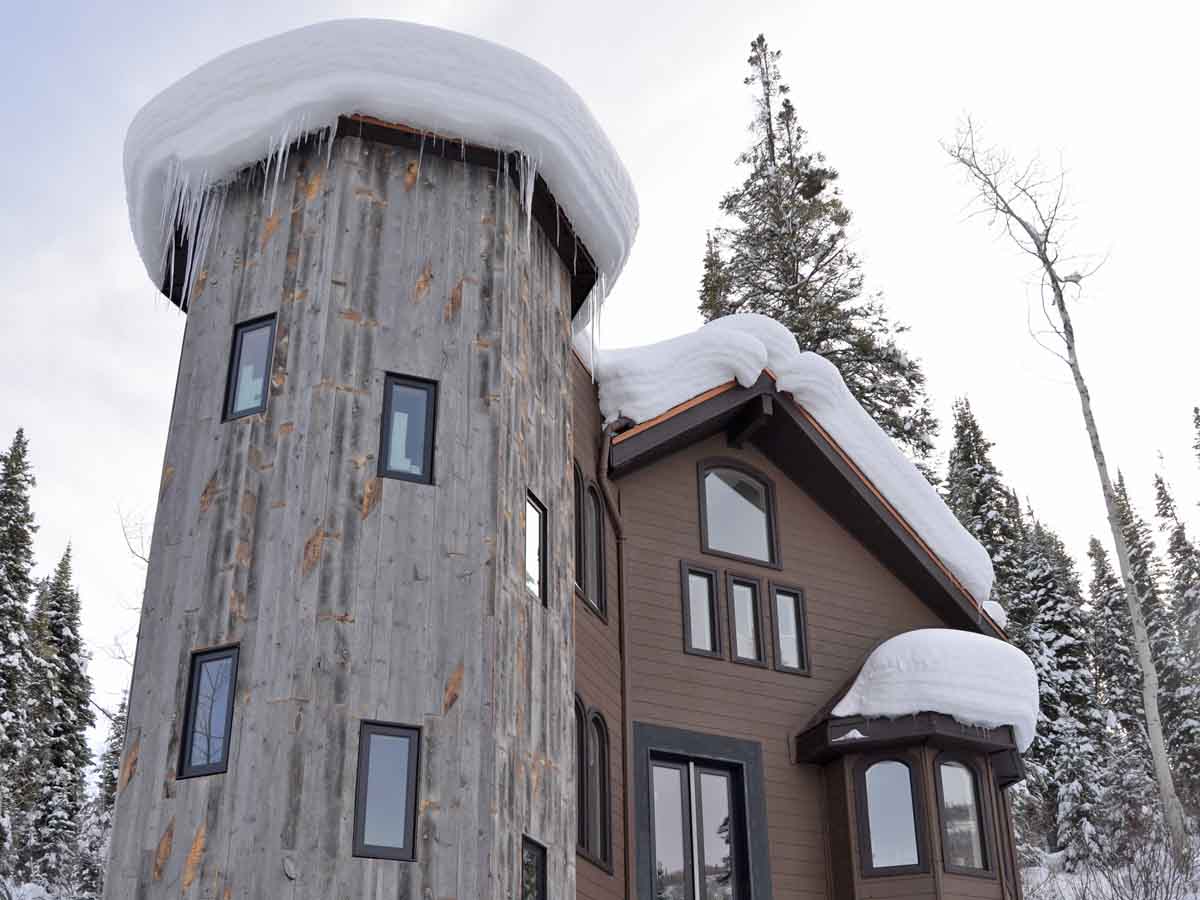Unique, vertical reclaimed wood siding on a turret connected to Colorado mountain home.