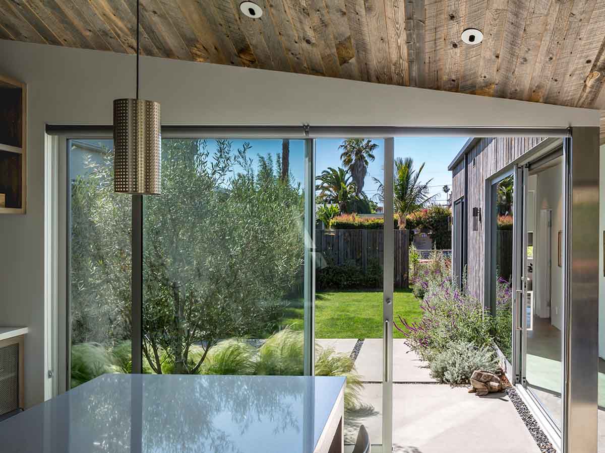 Light grey reclaimed wood ceiling in a modern kitchen with sliding glass doors.