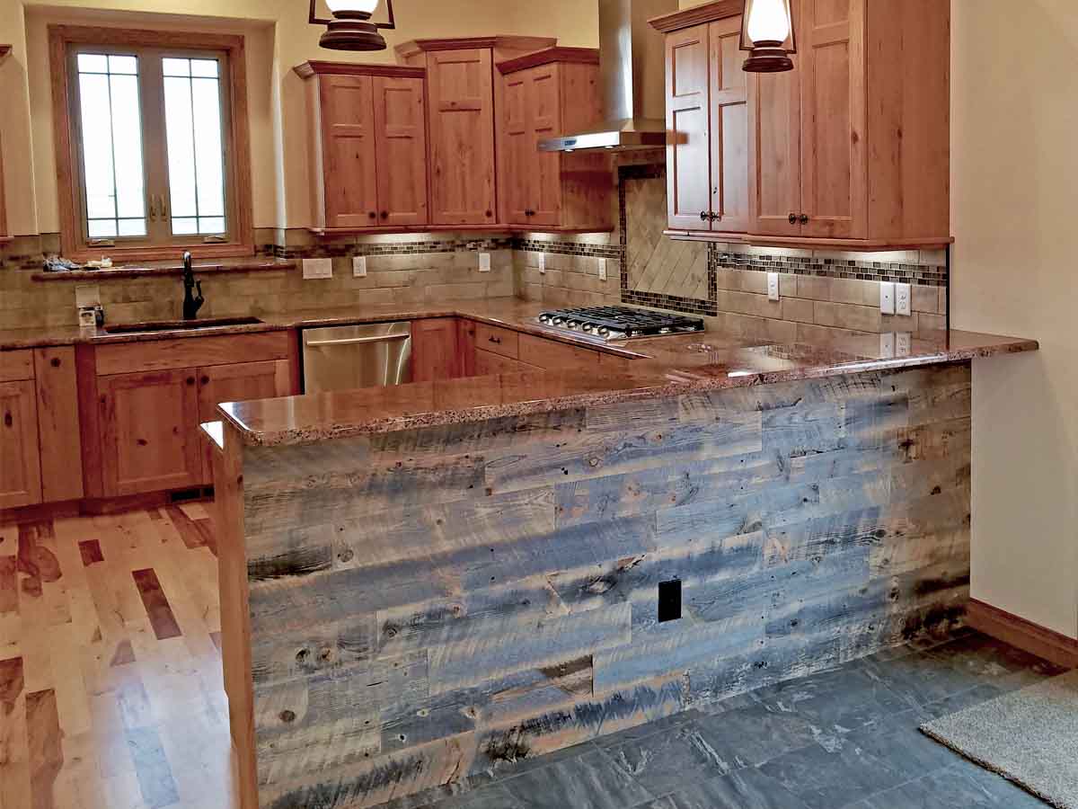 Rustic kitchen island with reclaimed wood paneling.