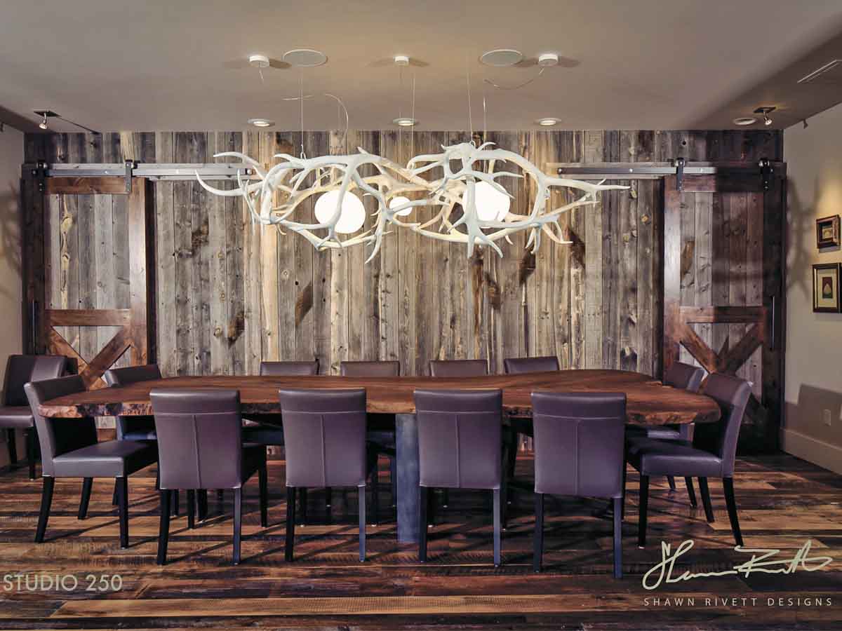 Vertical reclaimed wood accent wall in a dining room with a western motif.