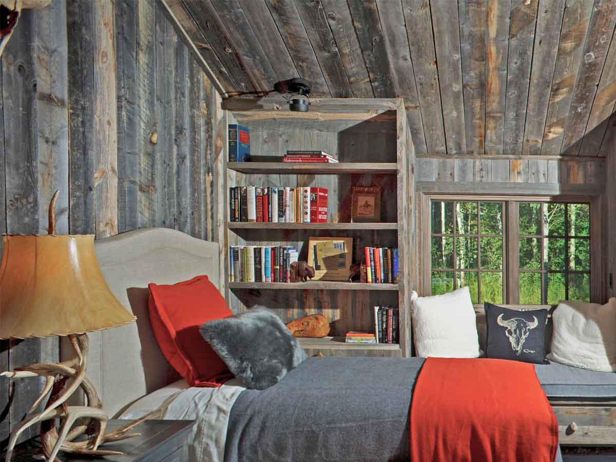 Bedroom in a mountain home with a grey reclaimed wood accent wall and ceiling by CLB Architects in Wyoming using recycled snow fence planks from Centennial Woods.