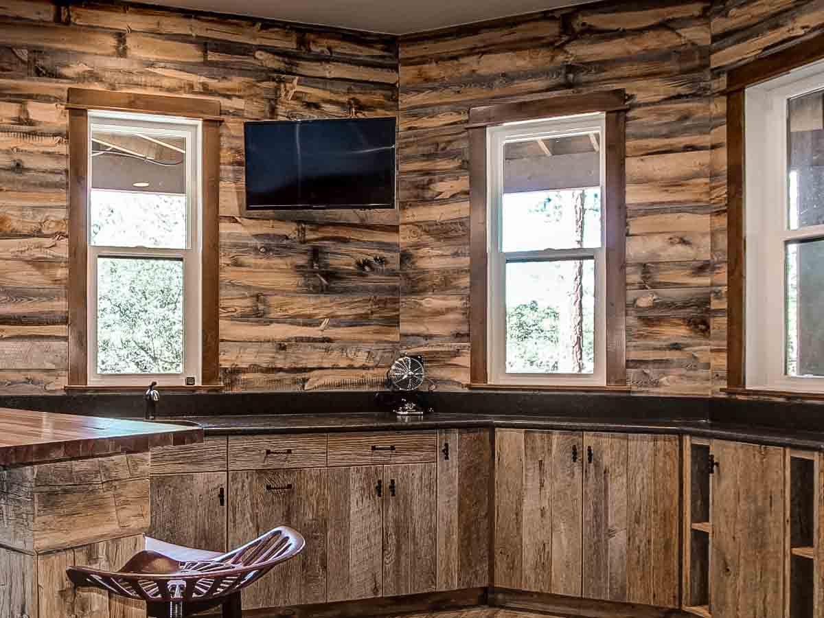 Brown rustic reclaimed wood accent wall in the kitchen of a country home.