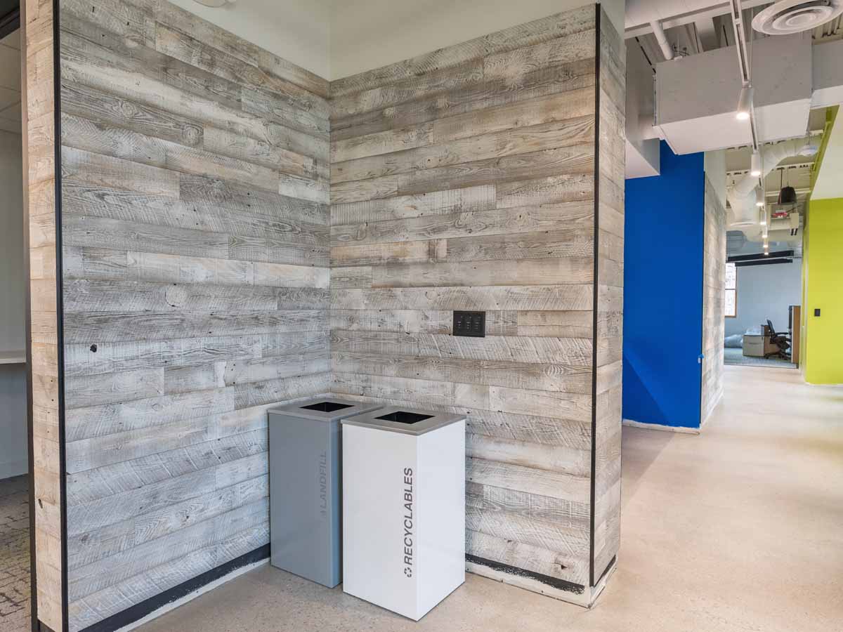 Whitewash painted reclaimed wood softens the look of a modern corporate office space.