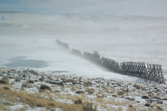 A Wyoming snow fence keeping snow drifts from forming on the interstate highway.