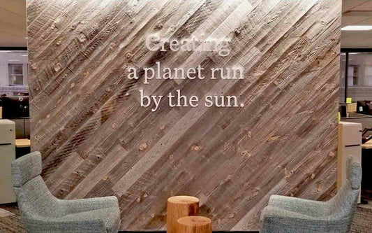 Using reclaimed wood as a biophilic element in architecture - an example of diagonally installed wall planks with lettering placed on top.