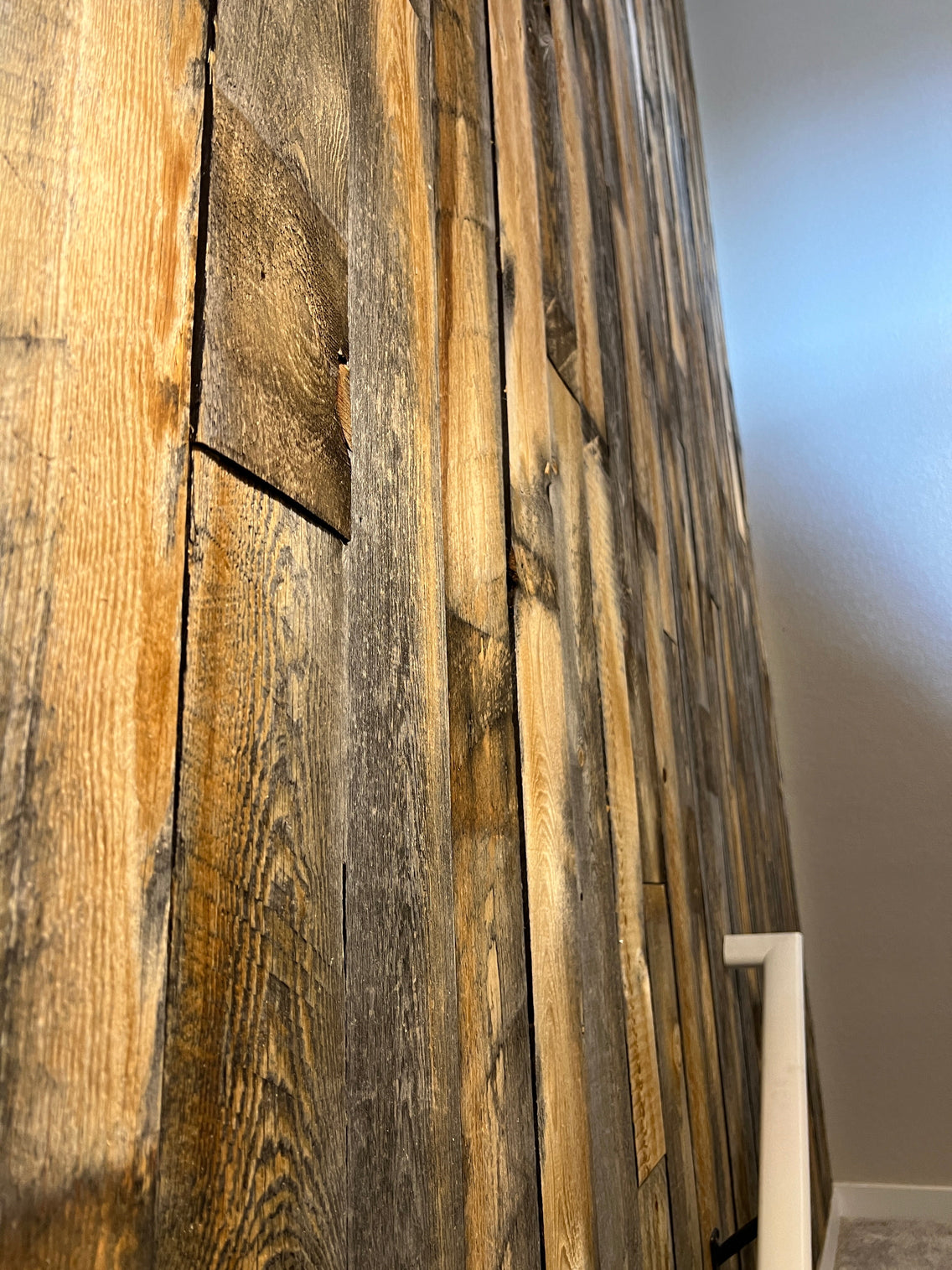 Close up detail photo of an accent wall made with salvaged wood planks from Centennial Woods.