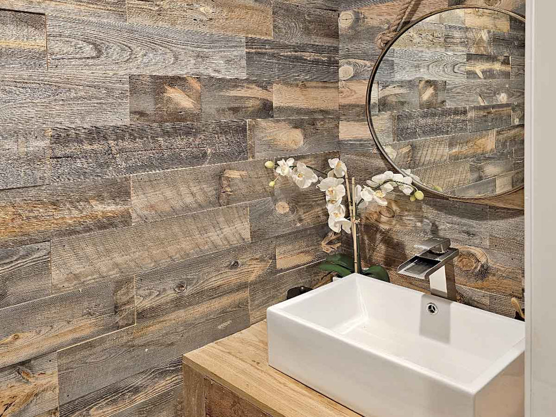 Bathroom with reclaimed wood wall in hues of brown and grey.