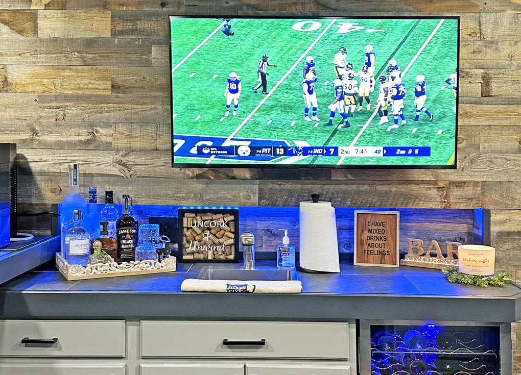 Mancave with an under counter fridge, widescreen tv, and a reclaimed wood wall from Centennial Woods