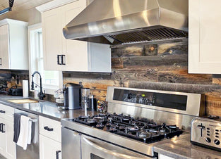 Reclaimed wood backsplash in a kitchen with stainless steel appliances.