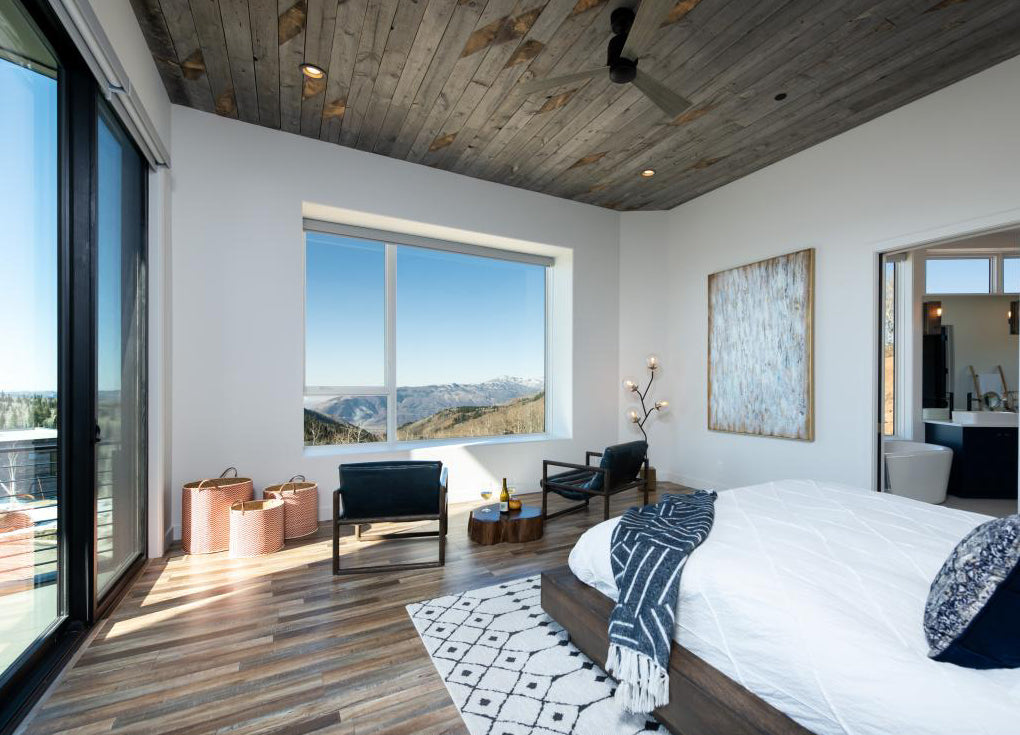 Grey reclaimed wood ceiling in a modern mountain house bedroom.