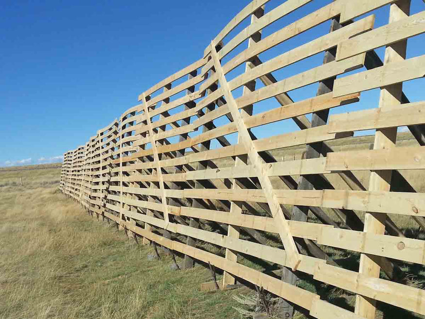 Image of a new snow fence built in a Wyoming field during summertime.