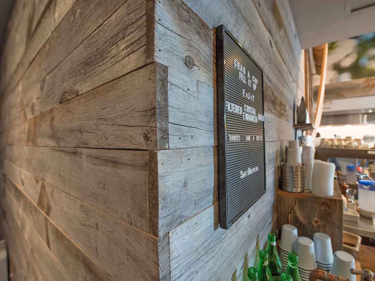 Gray reclaimed wood wall designs with natural edges in a restaurant