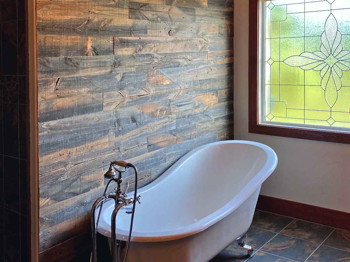 Brown and gray toned reclaimed wood in a bathroom with a claw tub