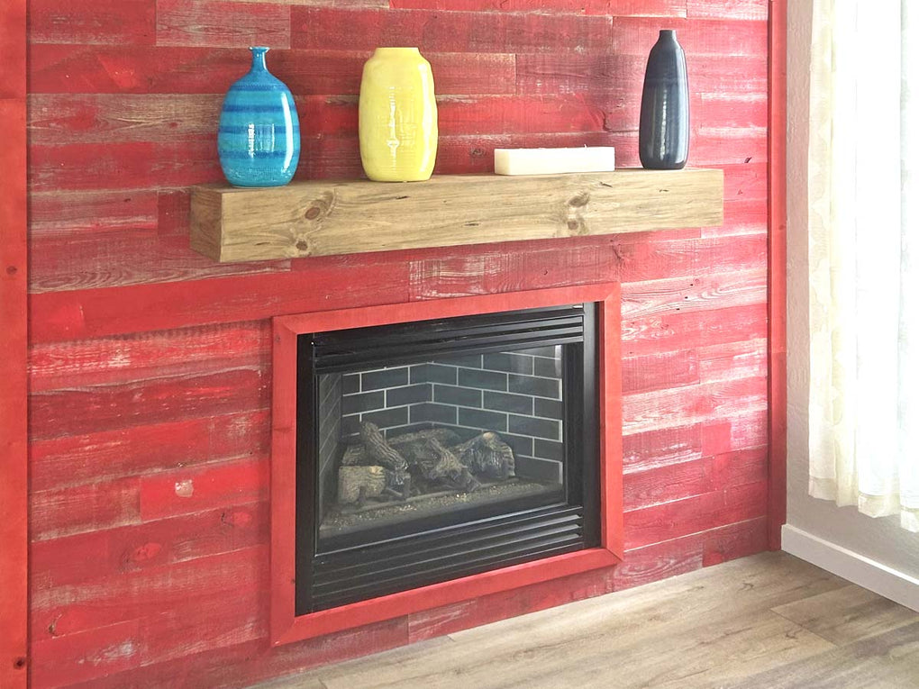 Red barn wood fireplace surround with mantel and decorative vases.