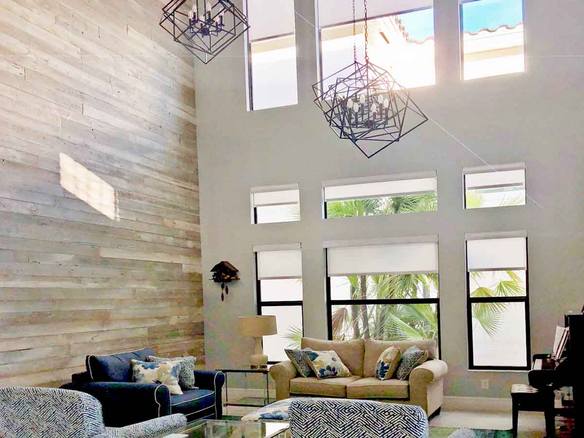 Whitewashed reclaimed wood accent wall in a high ceiling living room on the coast