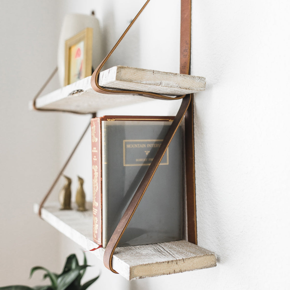Side profile of white reclaimed wood shelves with leather straps